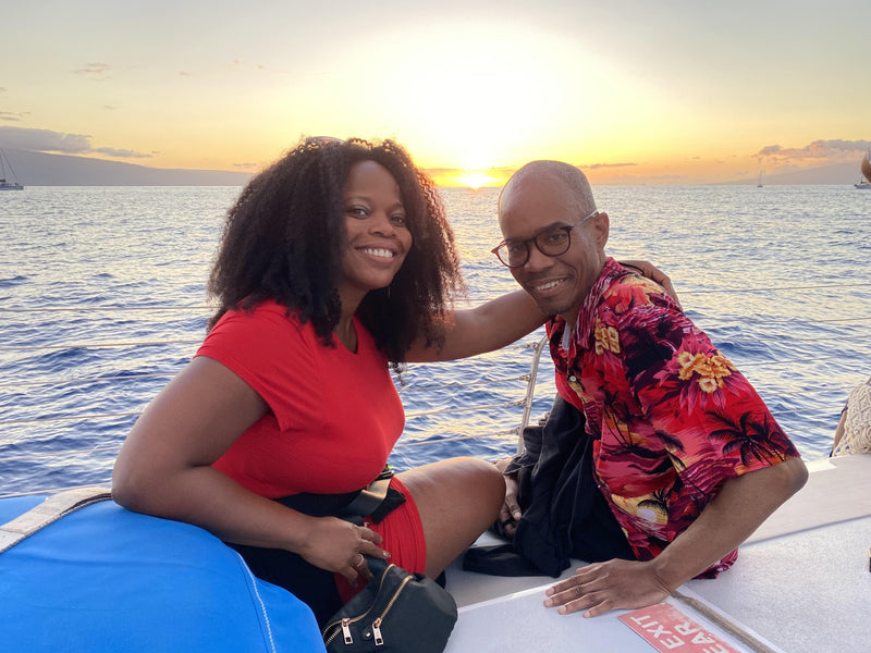 Couple wearing matching custom shirts on a cruise at sunset